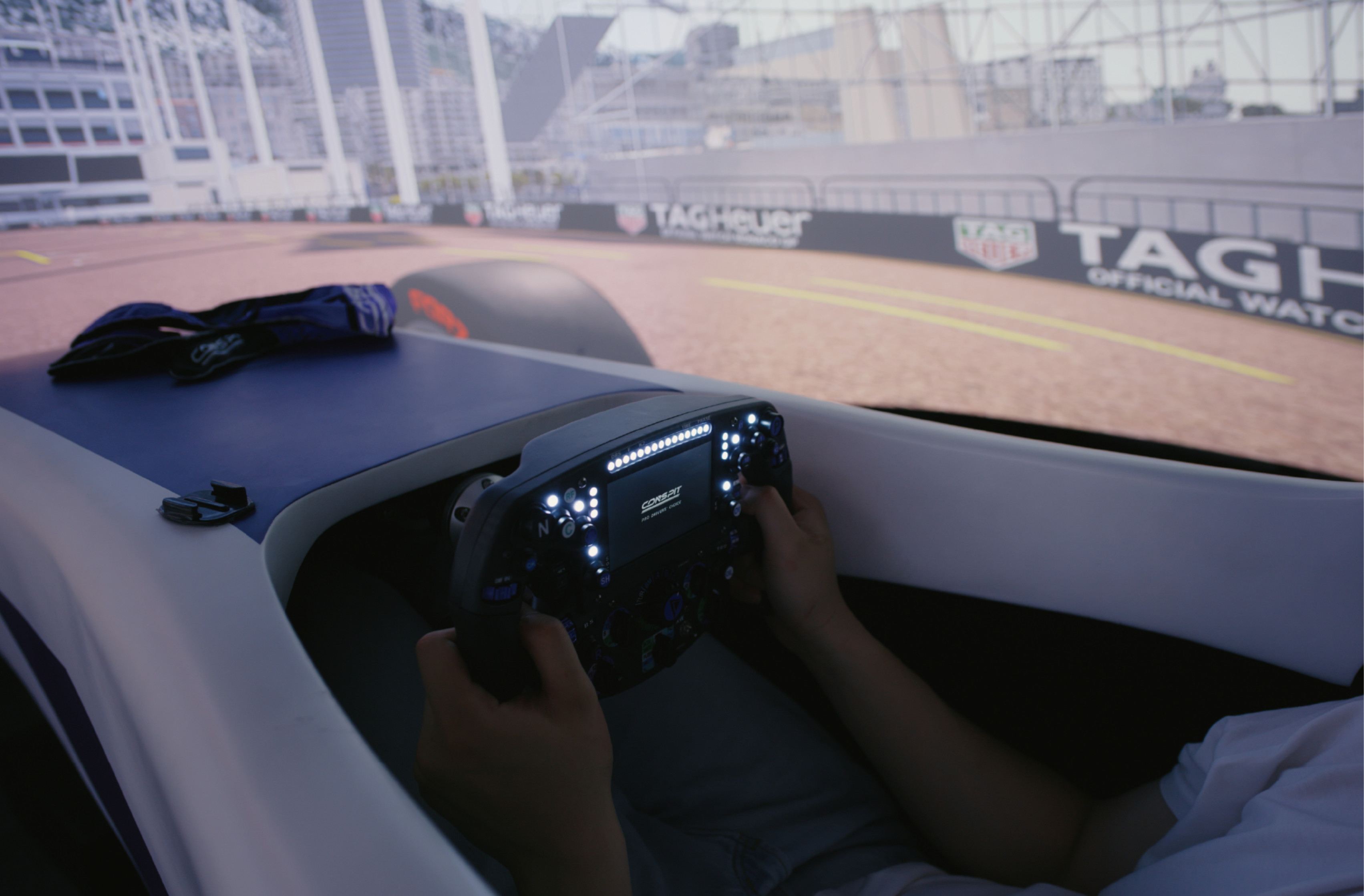 Driver racing in the CONSPIT FC-Lite formula cockpit in front of a large screen